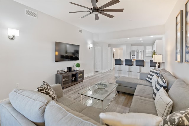 living room featuring light hardwood / wood-style floors and ceiling fan