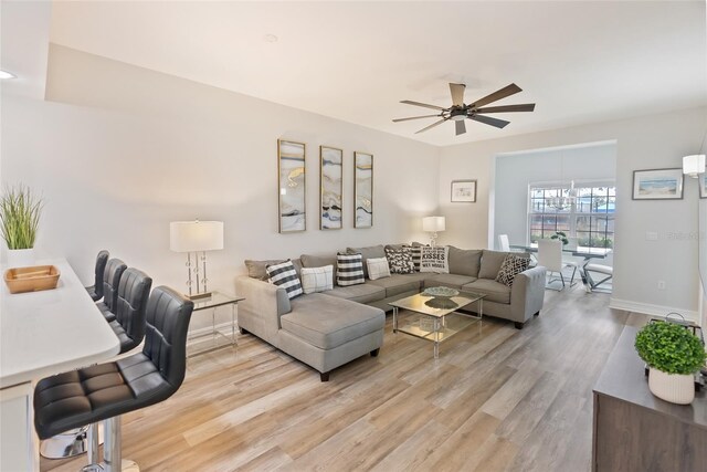 living room featuring ceiling fan and light hardwood / wood-style flooring