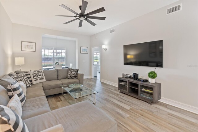 living room with ceiling fan and light hardwood / wood-style flooring