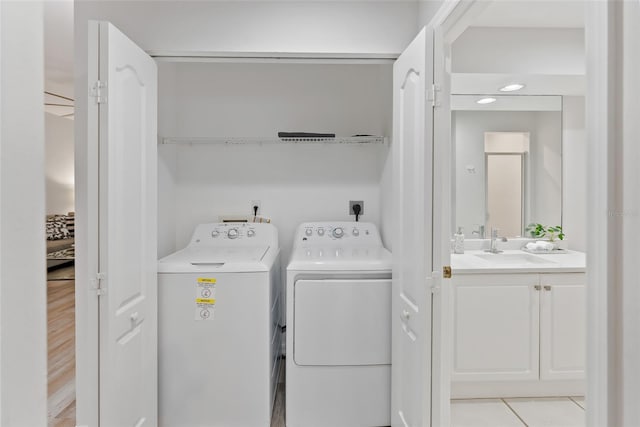 washroom with sink, washing machine and dryer, and light tile patterned flooring