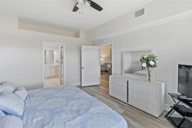 bedroom featuring light wood-type flooring, ensuite bath, and ceiling fan