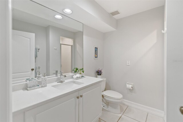 bathroom with toilet, tile patterned flooring, and vanity