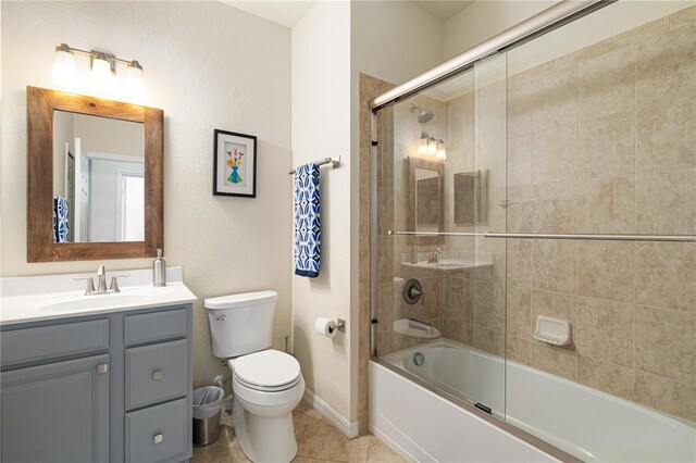 full bathroom with large vanity, combined bath / shower with glass door, toilet, and tile flooring