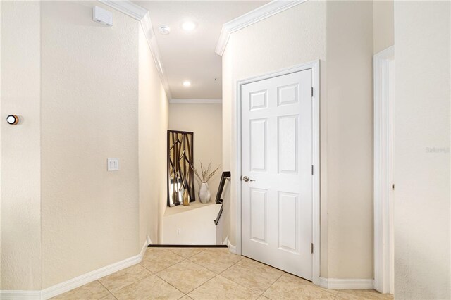 hall with crown molding and light tile floors