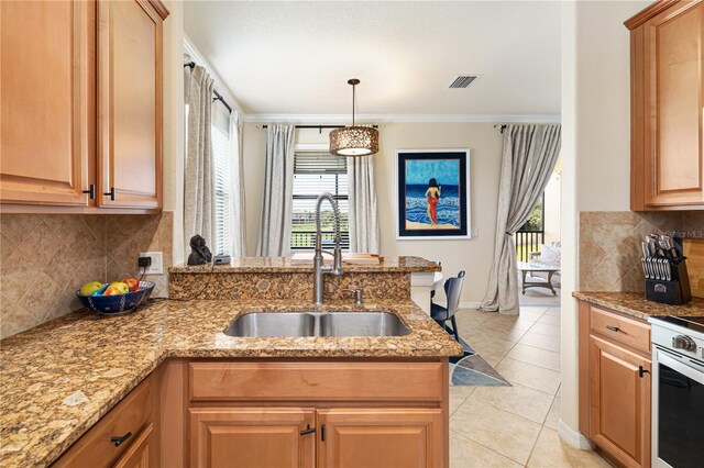 kitchen featuring tasteful backsplash, pendant lighting, sink, and light tile floors