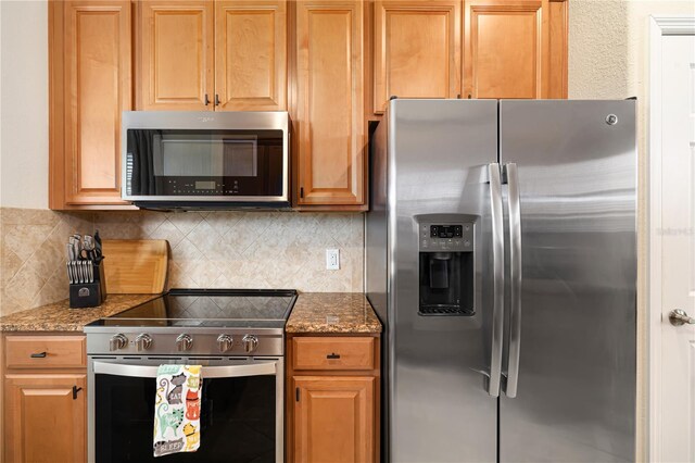 kitchen featuring backsplash, stainless steel appliances, and light stone countertops