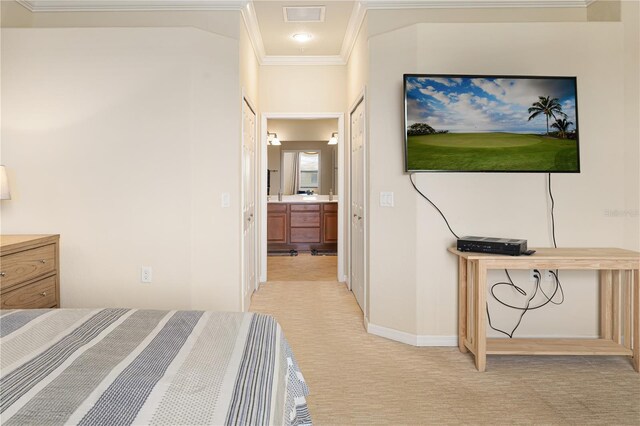 carpeted bedroom with crown molding and ensuite bathroom