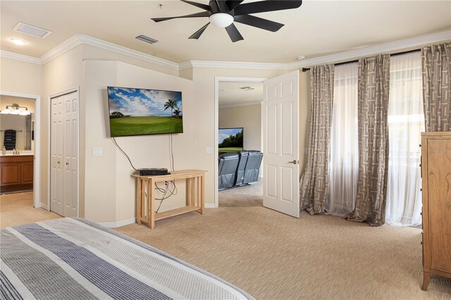 bedroom featuring light carpet, ceiling fan, crown molding, and ensuite bath