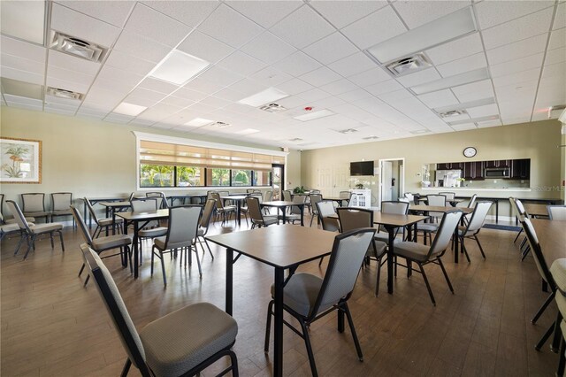 dining room with a drop ceiling and hardwood / wood-style floors