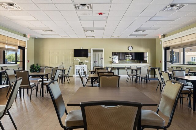 dining space featuring a drop ceiling and hardwood / wood-style flooring