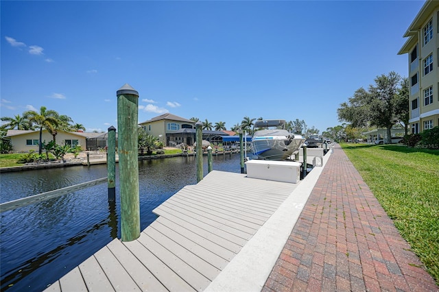 dock area with a lawn and a water view