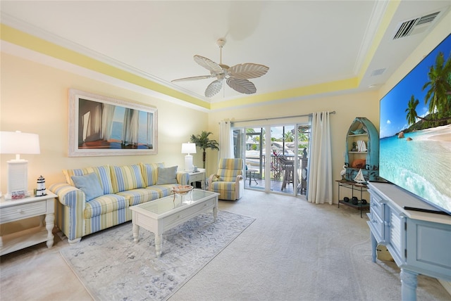 living room with ceiling fan, crown molding, and light colored carpet