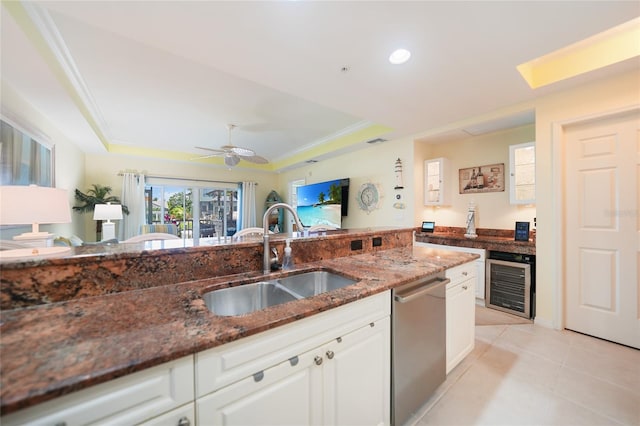 kitchen with beverage cooler, dishwasher, dark stone countertops, sink, and white cabinets