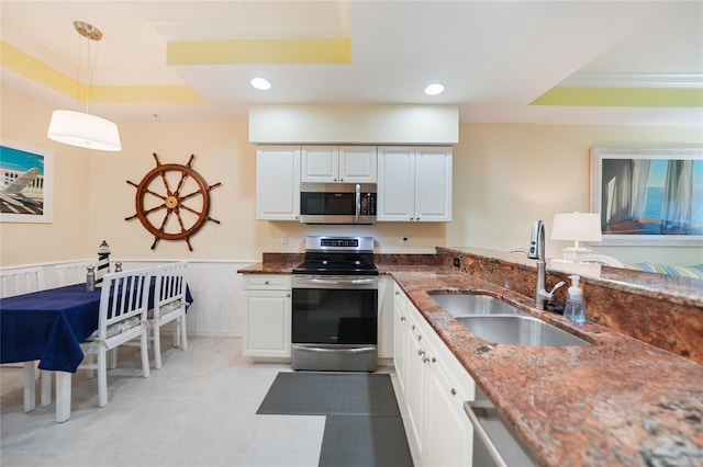 kitchen with white cabinets, a raised ceiling, and stainless steel appliances