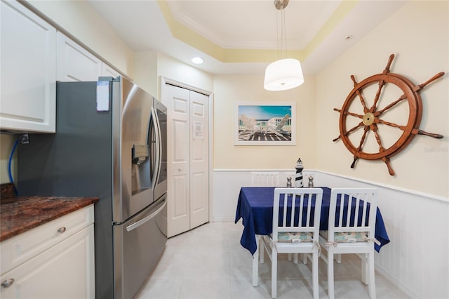 kitchen with white cabinetry, stainless steel fridge with ice dispenser, pendant lighting, light tile floors, and a raised ceiling