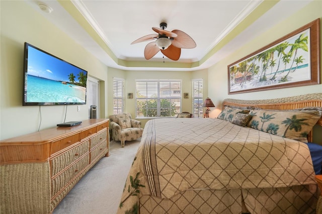 bedroom with carpet, ornamental molding, ceiling fan, and a raised ceiling