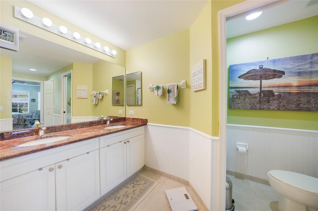 bathroom with tile floors, oversized vanity, toilet, and double sink