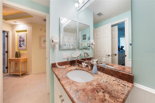 bathroom with tile flooring and vanity with extensive cabinet space