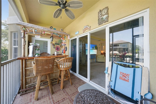 sunroom with a healthy amount of sunlight, ceiling fan, and lofted ceiling