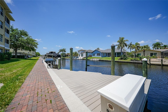 view of dock featuring a lawn and a water view