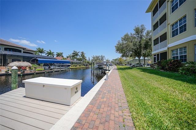 dock area with a lawn and a water view