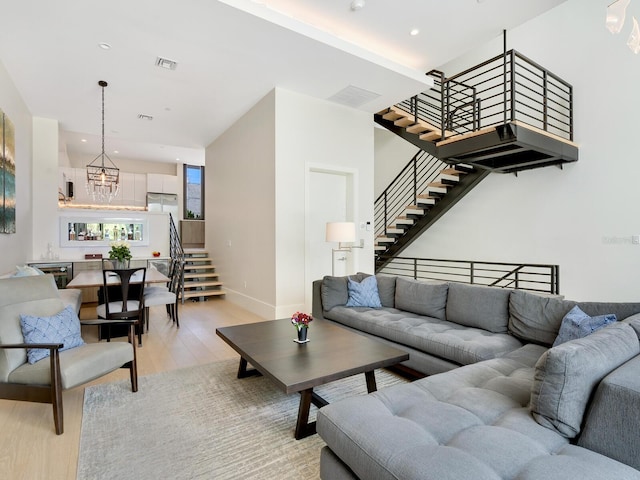 living room with light hardwood / wood-style flooring and an inviting chandelier