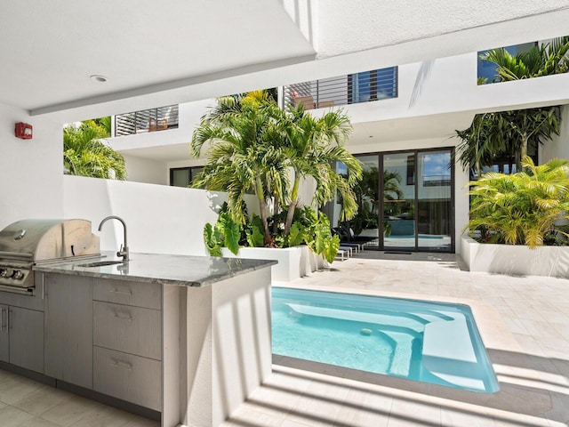 exterior space featuring a patio area, sink, an outdoor kitchen, and grilling area