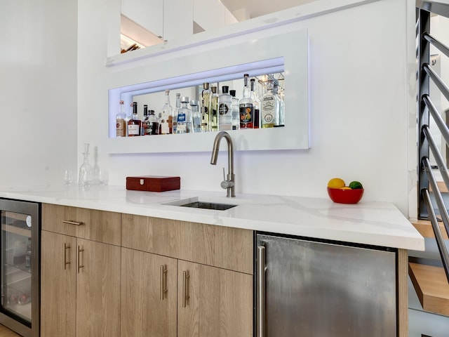 bar featuring light stone countertops, wine cooler, fridge, and sink