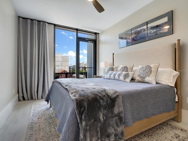 bedroom with ceiling fan, light hardwood / wood-style flooring, and expansive windows