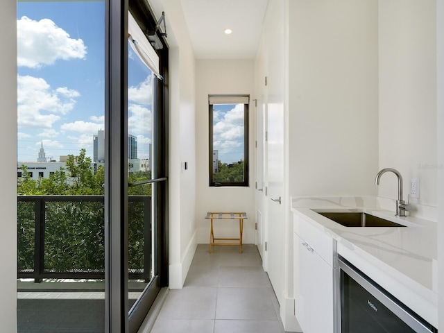 interior space with light tile patterned flooring, sink, and beverage cooler