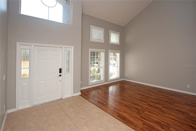 entryway with high vaulted ceiling and light wood-type flooring