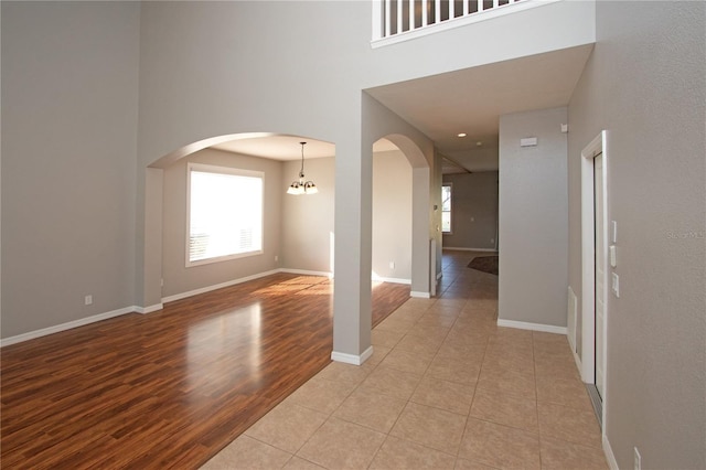 interior space with a towering ceiling, plenty of natural light, and light hardwood / wood-style floors