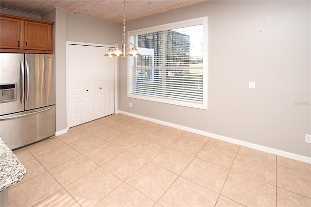 unfurnished dining area with an inviting chandelier, wood ceiling, and light tile patterned flooring