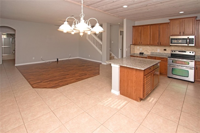 kitchen with appliances with stainless steel finishes, a center island, and light tile patterned floors