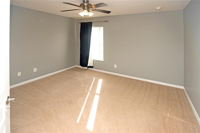 spare room featuring ceiling fan and light carpet