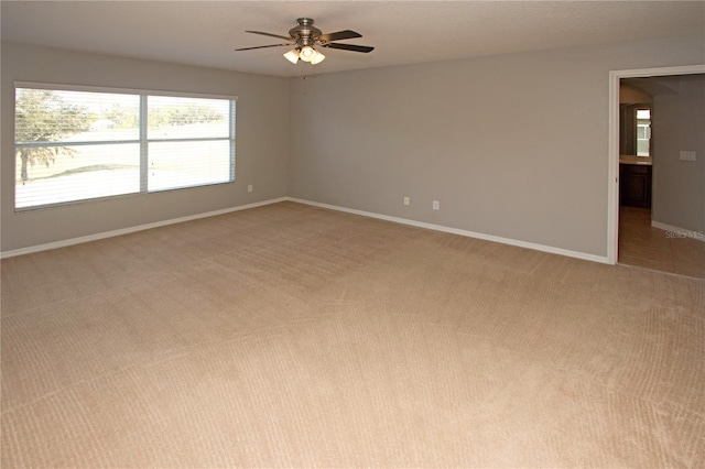 carpeted spare room with ceiling fan