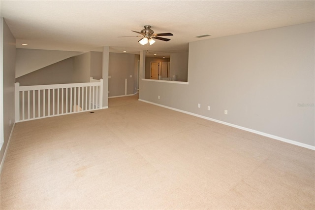 carpeted empty room with ceiling fan and a textured ceiling