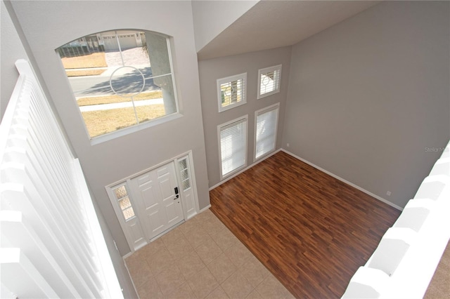 foyer entrance with wood-type flooring and a high ceiling