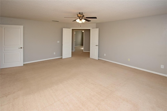 carpeted empty room featuring ceiling fan and a textured ceiling