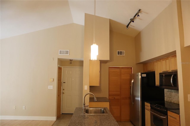 kitchen featuring stove, high vaulted ceiling, rail lighting, sink, and dark stone countertops