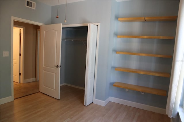 unfurnished bedroom with light hardwood / wood-style floors and a closet