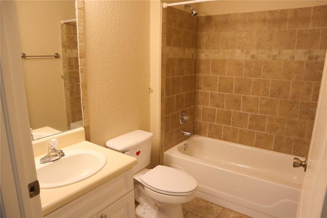 full bathroom with tile patterned flooring, vanity, tiled shower / bath, and toilet