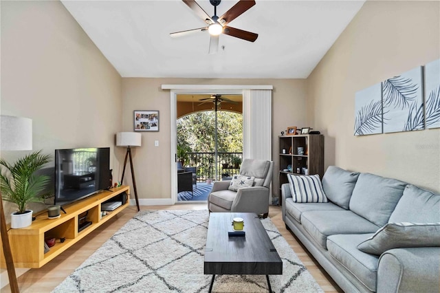 living room with light wood-style floors, vaulted ceiling, baseboards, and ceiling fan