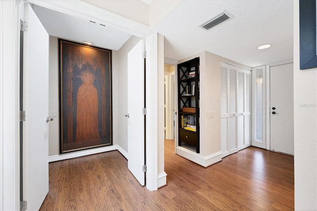 entryway featuring hardwood / wood-style flooring and a textured ceiling