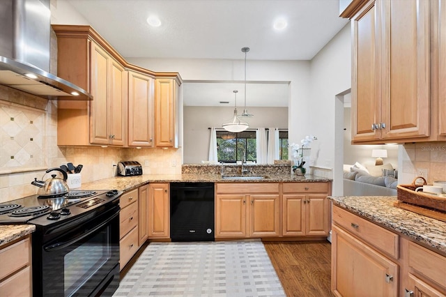 kitchen with sink, pendant lighting, light hardwood / wood-style flooring, wall chimney range hood, and black appliances