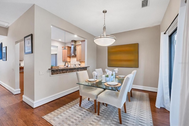 dining room featuring sink and dark hardwood / wood-style flooring