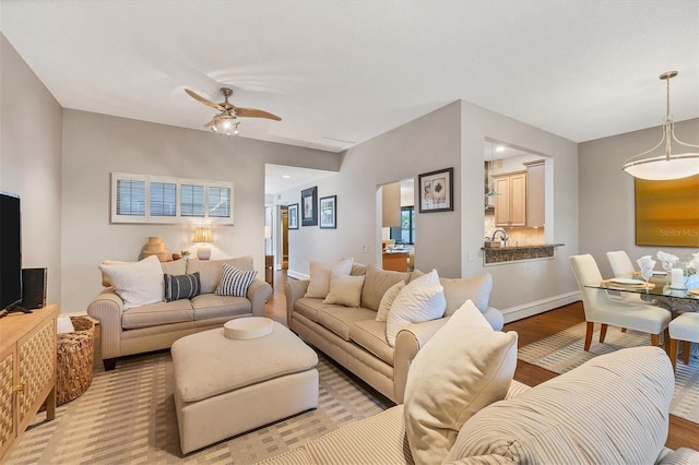 living room with light wood-type flooring and ceiling fan