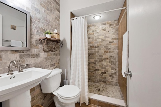 bathroom featuring toilet, a shower with curtain, backsplash, and sink