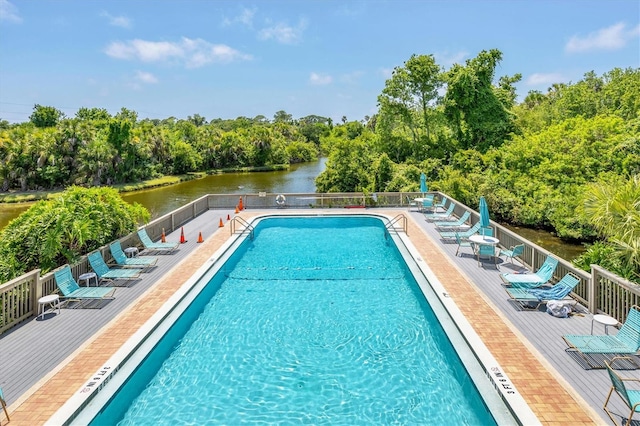 view of swimming pool featuring a patio area and a water view