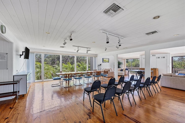 dining room with rail lighting, hardwood / wood-style flooring, and wood ceiling